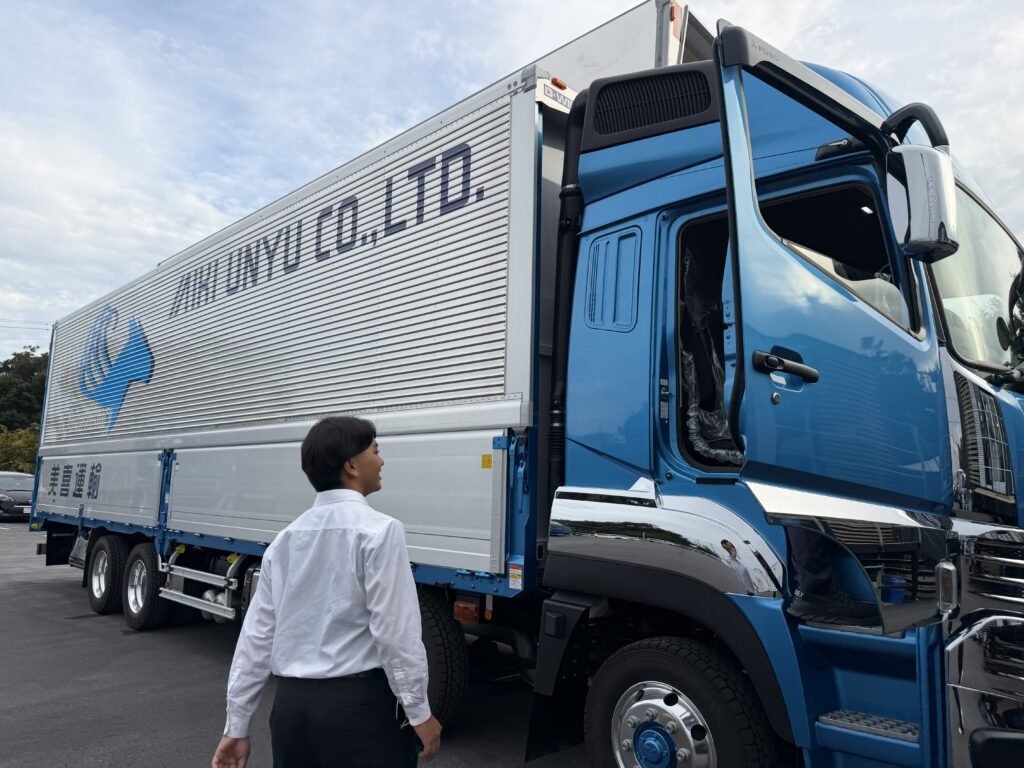 内定式に合わせて、新車のふそうスーパーグレードを納車。大きな真新しいトラックに喜ぶ内定者の様子。
